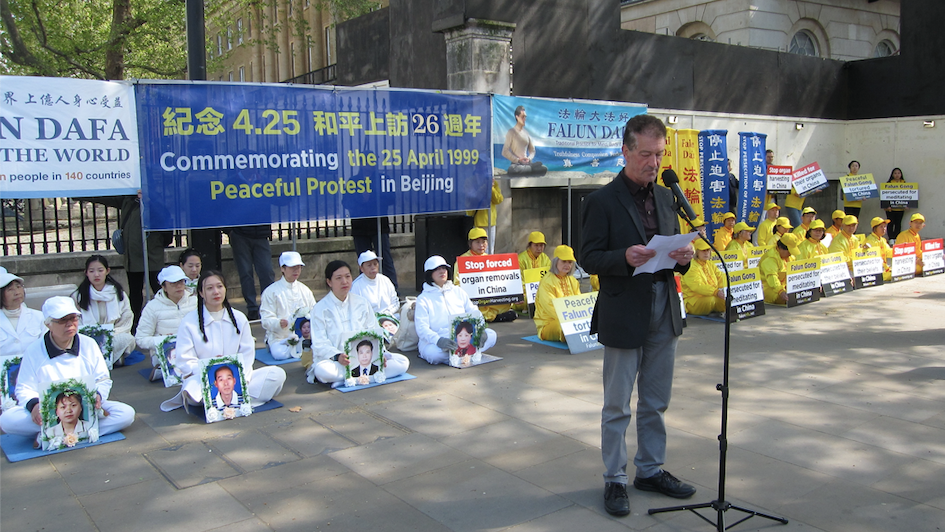 法輪功學員在首相府前舉行了新聞發布會。圖為歐洲法輪功之友主席約翰·迪先生髮言。（圖片來源：唐仲寶/SOH）