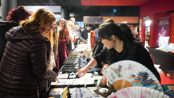 12月21日，觀眾在阿姆內維爾大劇院內購買神韻商品和《轉法輪》等書籍。（麥蕾／大紀元）