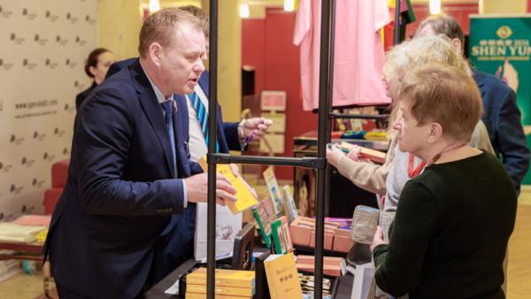 美國神韻巡迴藝術團在波蘭羅茲大劇院進行演出期間，觀眾早早來到劇院，他們對法輪大法書籍特別感興趣。（圖片來源：張清颻／大紀元）