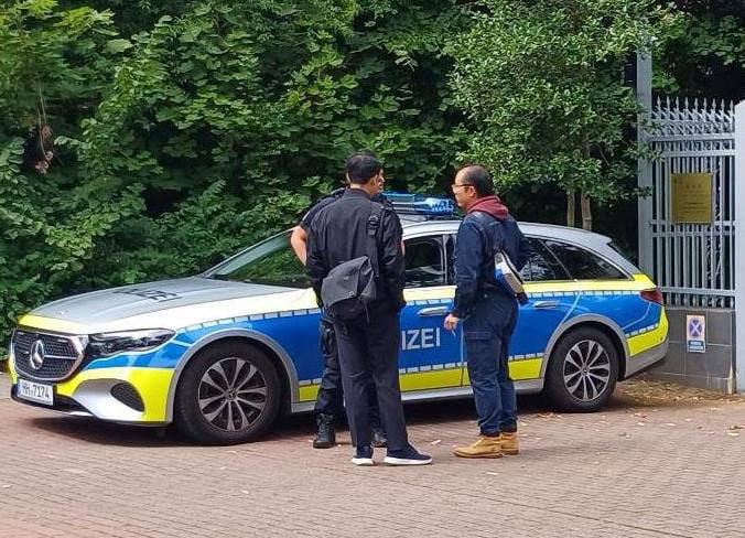 圖13:中共領館工作人員多次與德國警方交涉,試圖阻止法輪功學員的抗議活動。(明慧網)